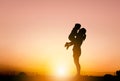 Silhouettes of mother and daughter playing at sunset evening sky background Royalty Free Stock Photo