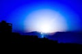 .Silhouettes of mountains against the background of sunset, solar eclipse, palm leaves, fire in the city of eilat in israel