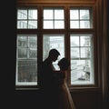 Silhouettes of newlyweds standing in the front of a bright window