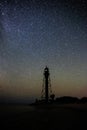 Silhouettes of the Old Lighthouse sandy beach and ocean against the background of the starry sky