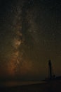 Silhouettes of the Old Lighthouse sandy beach and ocean against the background of the starry sky