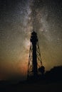 Silhouettes of the Old Lighthouse sandy beach and ocean against the background of the starry sky Royalty Free Stock Photo