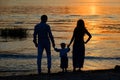 Silhouettes of parents and child on the background of the setting sun Royalty Free Stock Photo