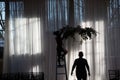 Silhouettes of people arranging the wedding decorations in the venue