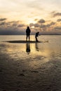 Silhouettes of unrecognizable people on the beach at sunset