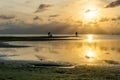 Silhouettes of unrecognizable people on the beach at sunset with the calm sea Royalty Free Stock Photo