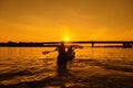 Silhouettes of people in boat at sunset. Man and woman ride boat on river. Small family trip Royalty Free Stock Photo