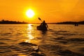 Silhouettes of people in boat at sunset. Man and woman ride boat on river. Small family trip Royalty Free Stock Photo