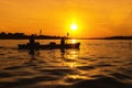 Silhouettes of people in boat at sunset. Man and woman ride boat on river. Small family trip Royalty Free Stock Photo