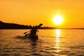 Silhouettes of people in boat at sunset. Man and woman ride boat on river. Small family trip Royalty Free Stock Photo