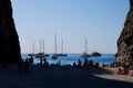 Silhouettes of people and boats at Cala Sa Calobra at sunset. Majorca, Spain.