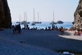 Silhouettes of people and boats at Cala Sa Calobra at sunset. Majorca, Spain.