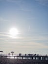 Silhouettes of people on the bridge on the seashore. People see off the sunset. Sea coast. Pier on the sea Royalty Free Stock Photo