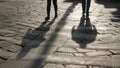 Silhouettes of people on the cobblestone pavement. Royalty Free Stock Photo