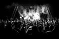 Silhouettes of people at a concert in front of the scene in bright light. Black and White