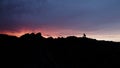 Silhouettes of people doing yoga in mountains at sunrise. Action. Tourists enjoying view on high rock in the early Royalty Free Stock Photo