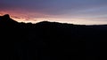 Silhouettes of people doing yoga in mountains at sunrise. Action. Tourists enjoying view on high rock in the early Royalty Free Stock Photo