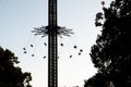 silhouettes of people enjoying a ride on chain swing at an amusement park Royalty Free Stock Photo