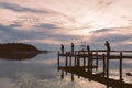 Silhouettes of people fishing in sunset.