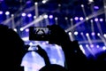 Silhouettes of a people hand shooting the concert with smart phones