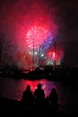 Silhouettes of people at harbor by fireworks night scene