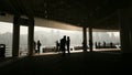 Silhouettes of people in the harbor of Victoria in Hong Kong. View of the sea and the city from inside the bridge