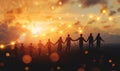 Silhouettes of people holding hands at sunset, symbolizing unity, teamwork, and collaboration. A glowing line graph Royalty Free Stock Photo