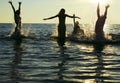 Silhouettes of people jumping in ocean Royalty Free Stock Photo