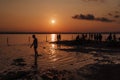 Silhouettes of people jumping in ocean and having fun at sunset. Tourism concept Royalty Free Stock Photo