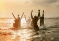 Silhouettes of people jumping in ocean Royalty Free Stock Photo