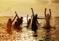 Silhouettes of people jumping in ocean Royalty Free Stock Photo