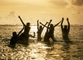 Silhouettes of people jumping in ocean Royalty Free Stock Photo