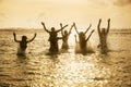 Silhouettes of people jumping in ocean Royalty Free Stock Photo