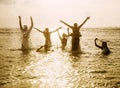 Silhouettes of people jumping in ocean Royalty Free Stock Photo