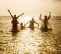 Silhouettes of people jumping in ocean Royalty Free Stock Photo