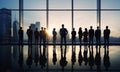 Silhouettes of people in a large room against a background of tall windows and buildings, a concept of collective Royalty Free Stock Photo