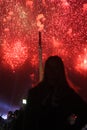 Silhouettes of people looking at colorful red salute explosions in the sky. Royalty Free Stock Photo