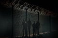 Silhouettes of people near the fence with barbed wire Royalty Free Stock Photo