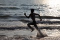 Silhouettes of people play in the waves in the Bekal beach