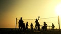 Silhouettes of people playing beach volleyball at sunset. Royalty Free Stock Photo