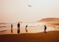 Silhouettes of people playing and flying a kite in sandy Golden Beach, Karpasia, Cyprus Royalty Free Stock Photo