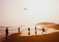 Silhouettes of people playing and flying a kite in sandy Golden Beach, Karpasia, Cyprus Royalty Free Stock Photo