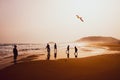 Silhouettes of people playing and flying a kite in sandy Golden Beach, Karpasia, Cyprus Royalty Free Stock Photo