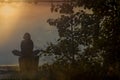 Silhouettes of people on the river bank in the setting sun Royalty Free Stock Photo