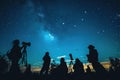 Silhouettes of people stargazing against a night sky