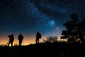 Silhouettes of people stargazing against a night sky