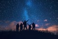 Silhouettes of people stargazing against a night sky