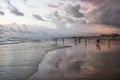 Silhouettes of a people and surfers at the beach.