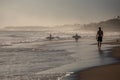 Silhouettes of a people and surfers at the beach.