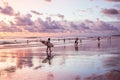 Silhouettes of a people and surfers at the beach.